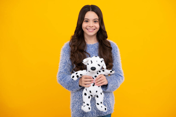 Teenager girl 12, 13, 14 year old hold soft toy for birthday on yellow background. Kid with her toys. Happy teenager, positive and smiling emotions of teen girl - Φωτογραφία, εικόνα