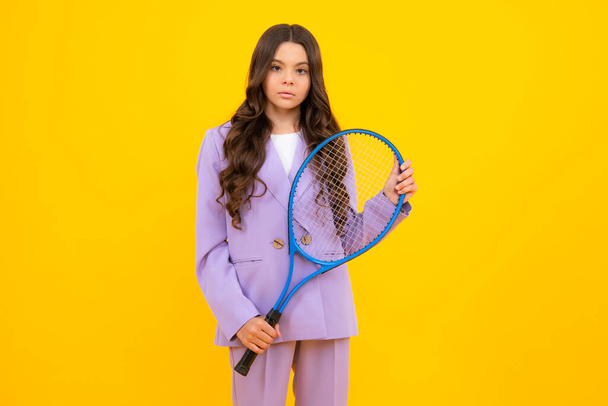 10代の子供のテニス選手は、孤立した黄色のスタジオの背景の上にテニスラケットを保持します。子供のためのスポーツとフィットネス。ファッションとスポーツのコンセプト - 写真・画像