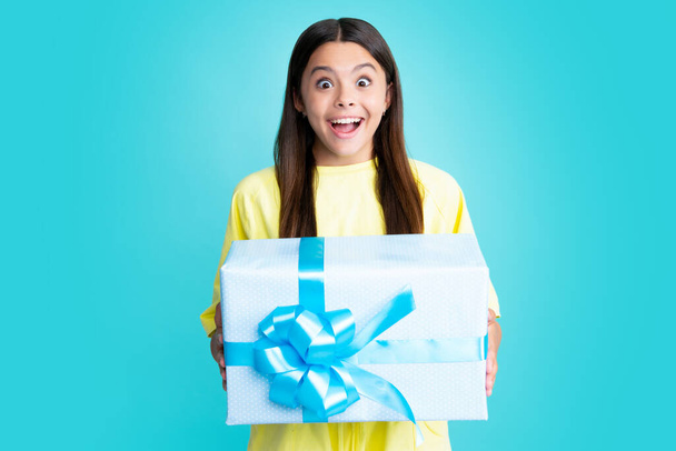 Emotional teenager child hold gift on birthday. Funny kid girl holding gift boxes celebrating happy New Year or Christmas. Surprised face, surprise emotions of teenager girl - Фото, зображення