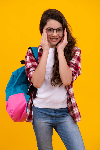 School teen girl in with backpack. Teenager student on isolated background. Kids learning, education, studying and knowledge. Happy teenager, positive and smiling emotions of teen schoolgirl - 写真・画像