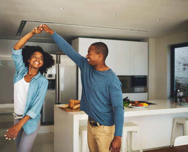 Кружится. веселая молодая пара танцует вместе на кухне дома в течение дня - Фото, изображение