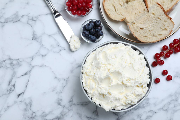 Tasty cream cheese, fresh berries and bread on white marble table, flat lay. Space for text - Фото, зображення