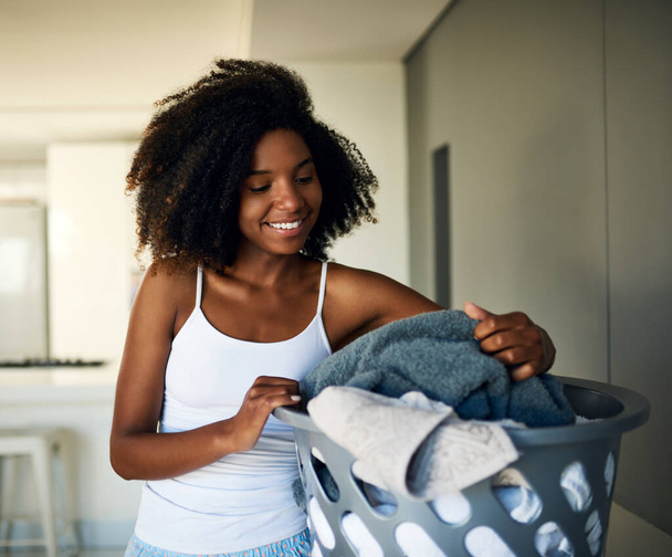 Keeping her home in order starting with laundry. an attractive young woman doing the laundry at home - Foto, Imagen