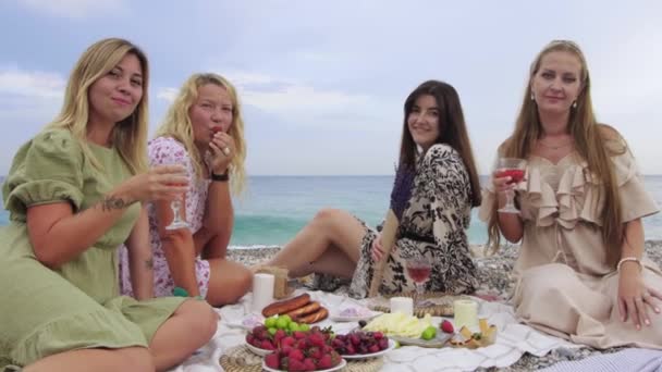 Четыре женщины на пикнике у моря - смотрят в камеру. Средний выстрел - Кадры, видео