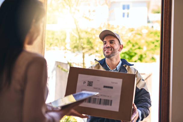 Your order is right here. a courier making a delivery to a customer - Foto, afbeelding