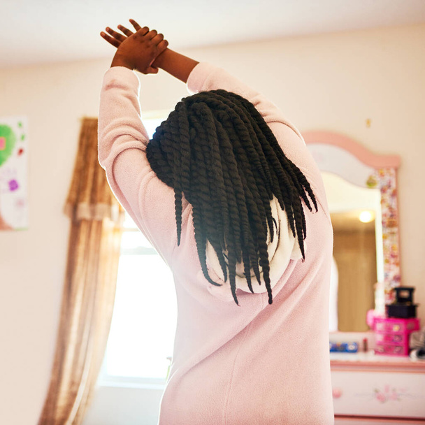 After a nights rest stretching is important. Rearview shot of an unrecognizable little girl stretching in her bedroom - Photo, Image