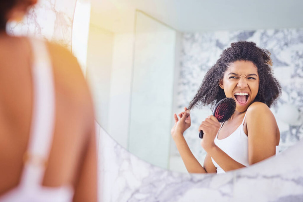 Feel fabulous, look fabulous. an attractive young woman singing while brushing her hair in the bathroom at home - Fotoğraf, Görsel