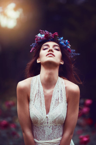 The world needs more beauty like hers. Portrait of a beautiful young woman wearing a floral head wreath outdoors - Foto, Bild