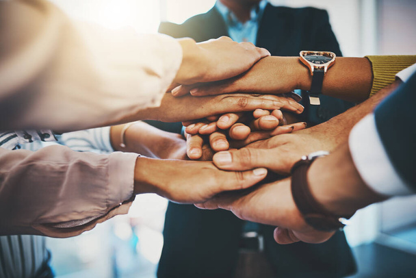 Together we will take business to the top. Closeup shot of an unrecognizable group of businesspeople joining their hands together in a huddle - Foto, immagini