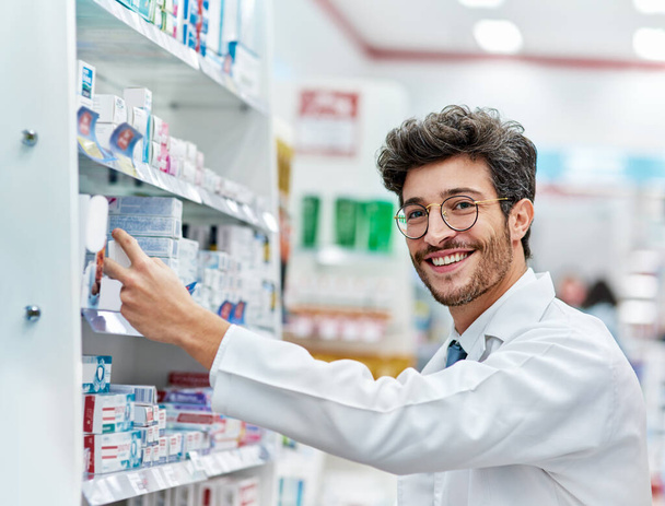 Keeping his shelves well-stocked. Portrait of a pharmacist working in a pharmacy - Foto, Imagen