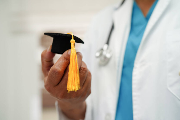 Asian woman doctor holding graduation hat in hospital, Medical education concept. - Photo, image