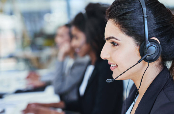 Youve reached our customer care, how may I assist. a young woman working in a call centre - Foto, Imagen