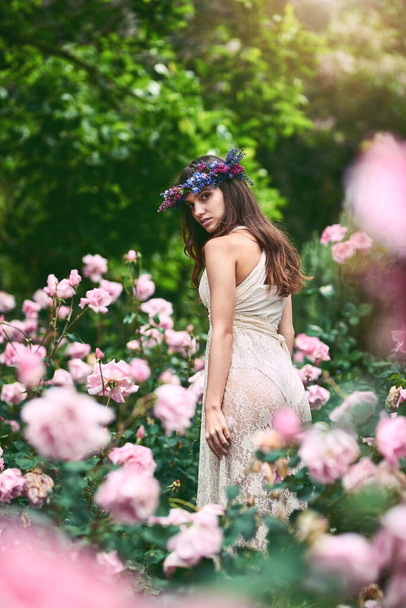 You are you and that is your power. a beautiful young woman wearing a floral head wreath posing in nature - Foto, afbeelding