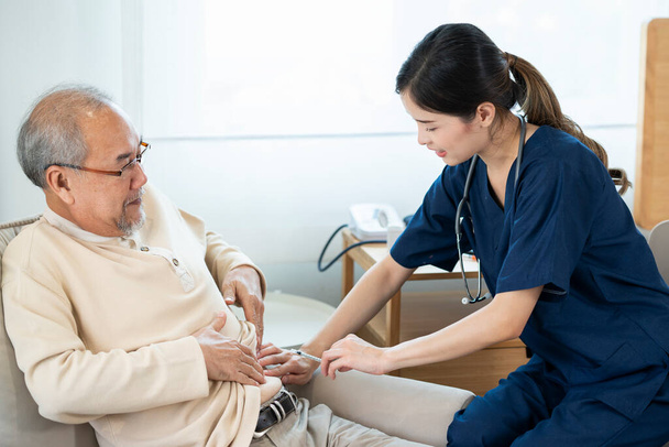 老人ホームサービスでアジアの看護師老人は、血液中の高糖を防ぐためにインスリンを注入することにより、,老人は糖尿病です.  - 写真・画像