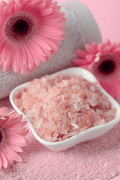Spa composition with pink salt, flowers, and towel. - Foto, Imagem