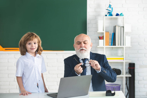 Back to school. Teacher and child. Education and learning concept. Schoolboy in classroom. Old teacher and young pupil - Foto, Bild