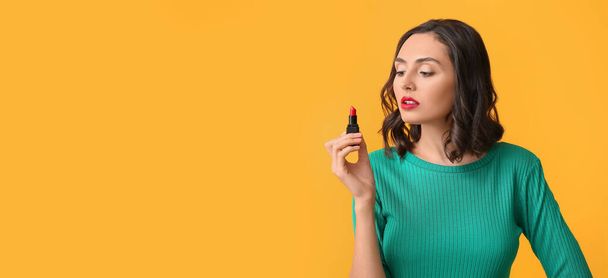 Beautiful young woman with lipstick on yellow background with space for text - 写真・画像