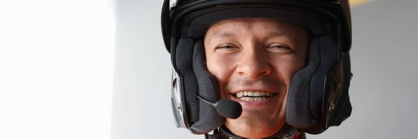 Uomo sorridente in casco da moto con vivavoce. Comunicazione durante la guida di un concetto di moto - Foto, immagini