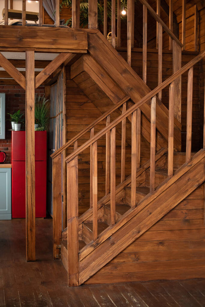Wooden Stairway goes up. Country wooden house is spacious on two levels. Room with wooden stairway leading to second floor of modern flat. Modern staircase with wooden steps in flat.  - Fotoğraf, Görsel