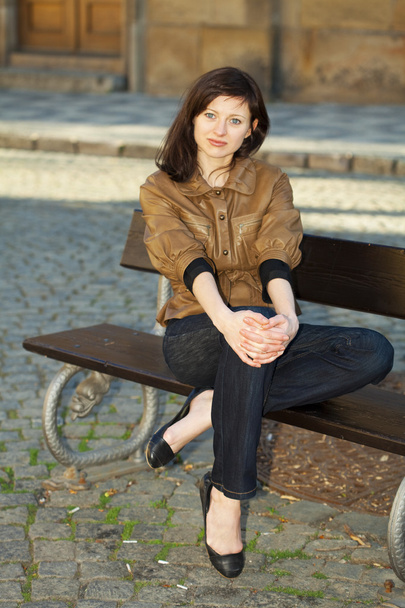 Beautiful young woman sitting on a bench - 写真・画像