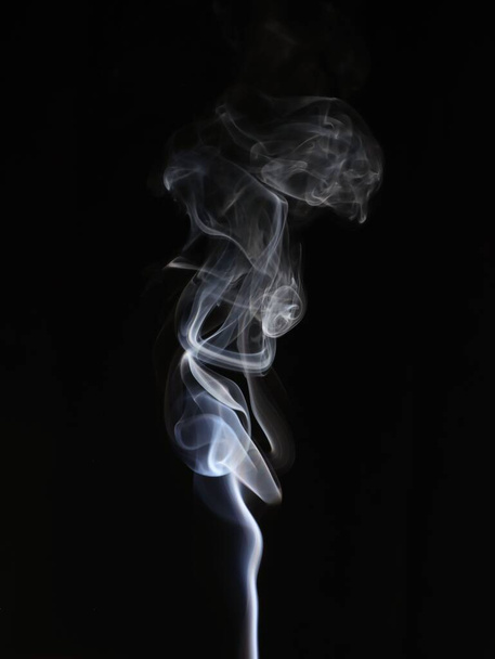 A closeup of an abstract light white smoke swirl on a black background - Photo, image
