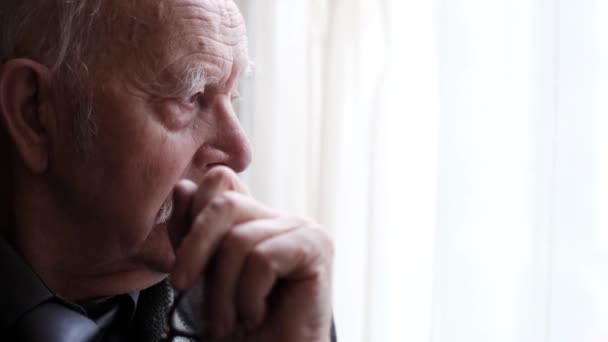 Portrait of upset grandfather by the window, close up portrait of an elderly man who is depressed. 4k vido - Footage, Video