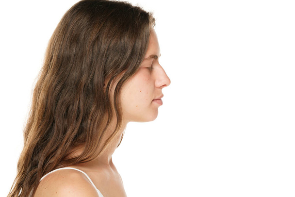 Profile of a young woman without makeup and closed eyes on a white background. - Foto, immagini