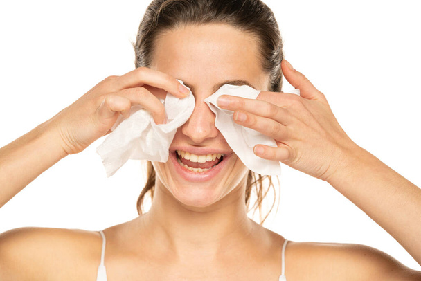 A young happy woman removing makeup with the wet tissues  on white background. - Foto, immagini