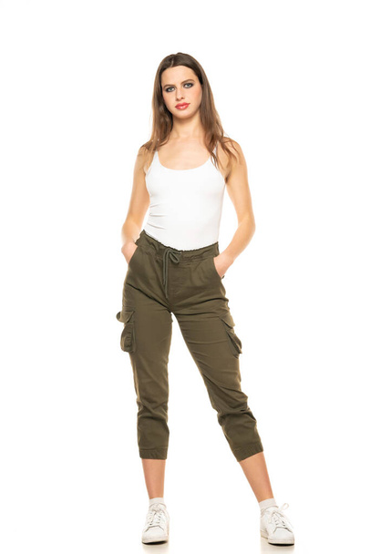 Young woman with three-quarter pants and shirt posing in the studio on white background. - Photo, Image
