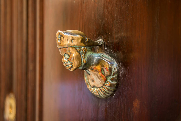 Old wooden doors with rings and old-fashioned vintage steel knocker handle close up. - Fotó, kép