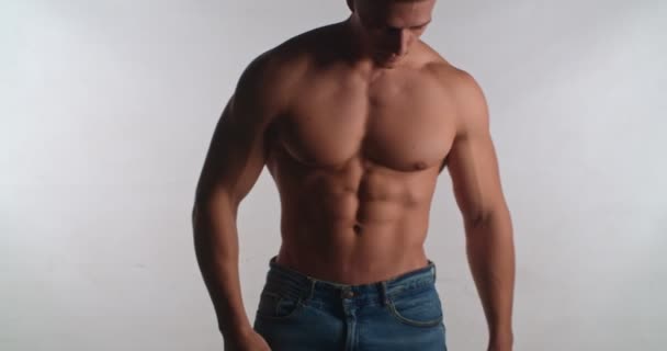 Half naked man with well build body standing and turning isolated in studio - Metraje, vídeo