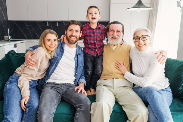 Portrait of senior and young couples with their children looking at camera at home - Photo, Image