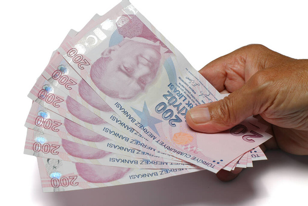 Idősebb ember ráncos kezek kezében török líra bankjegyek fehér háttérben.Pénzügyi valuta válság koncepció. - Fotó, kép