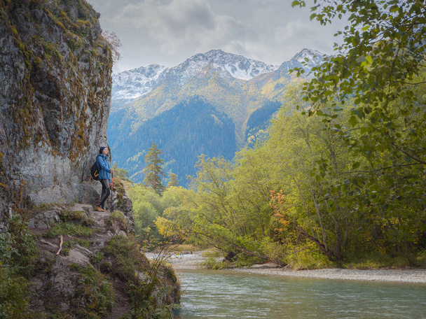 trip to Caucasus mountains, Arkhyz, Teberdinsky reserve. concept of discovery and exploration of wild places in early autumn. woman standing on the river bank - Photo, Image