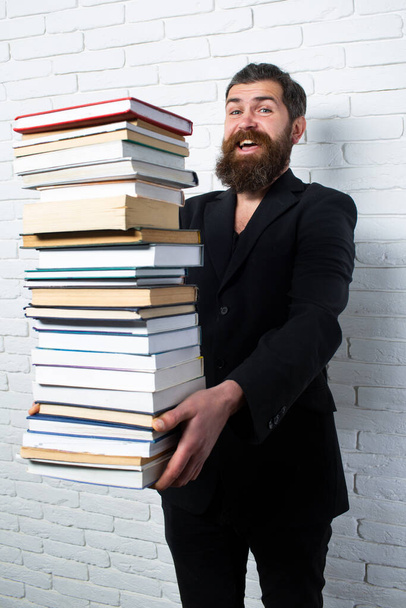 Funny teacher or professor with book stack. Thinking serious mature teacher. Falling books concept. Mature professor, middle aged teacher, bearded fun man. Books stacked fall - Zdjęcie, obraz