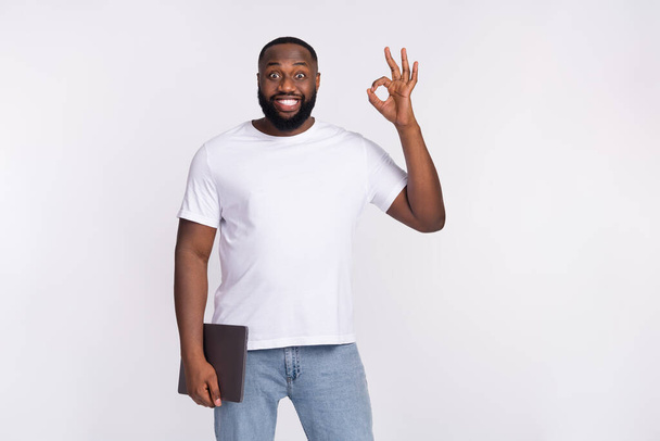 Photo of impressed funny man wear casual t-shirt holding modern device showing okey isolated white color background. - Φωτογραφία, εικόνα