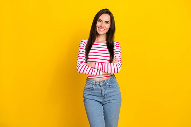 Photo portrait of cute young lady stand crossed hands clothes poster dressed trendy striped garment isolated on yellow color background. - Photo, Image