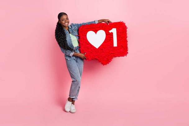 Full size photo of cheerful lovely girl hold huge like reaction icon wear denim outfit isolated on pink color background. - Photo, image