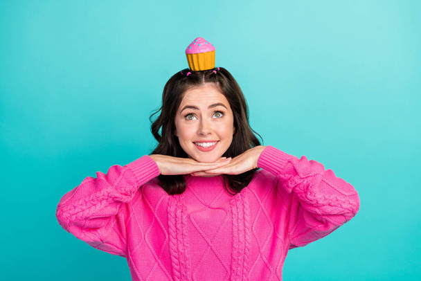 Photo of toothy beaming sweet girl wavy hairdo wear pink pullover dreaming about cupcake hands chin isolated on teal color background. - Foto, immagini