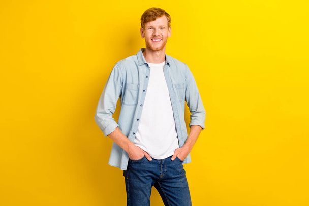 Photo portrait of nice young man model posing hands hold pockets smiling dressed trendy denim outfit isolated on yellow color background. - Фото, зображення