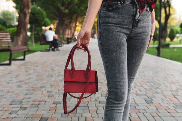 young girl walks in the park with a handbag - Фото, изображение