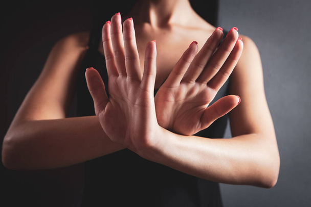 Closeup image of a woman outstretched hand and showing stop hand sign - Foto, afbeelding