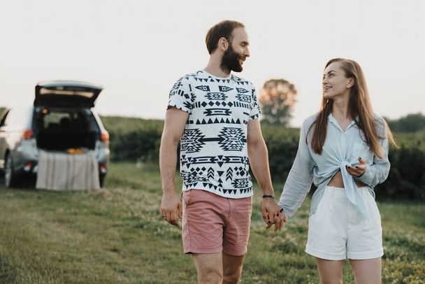 Middle-aged couple enjoying road trip, caucasian man and woman walking outdoors in nature outside the city - Photo, Image
