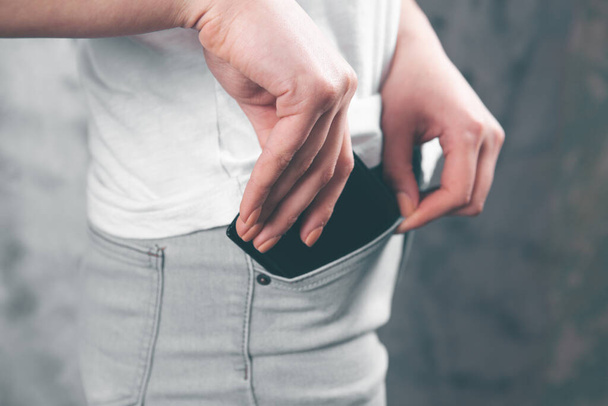 woman puts wallet in her pocket - Foto, Bild