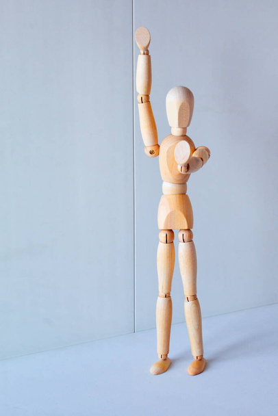 Concept of making the stop signal with the figure of a wooden boy - Foto, Imagen