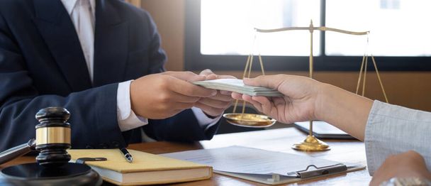 lawyer or judge is taking a bribe. In the client's courtroom at the lawyer's office In order to bribe to gain an advantage in the form of lawsuits, the concept of bribery and corruption in la - Photo, image