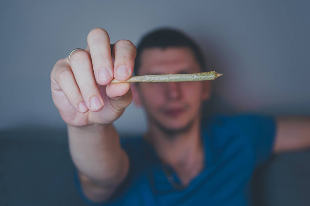 Крупним планом дорослий чоловік запалює сірники і курить медичний марихуану суглоб. Концепція рослинної та альтернативної медицини
 - Фото, зображення