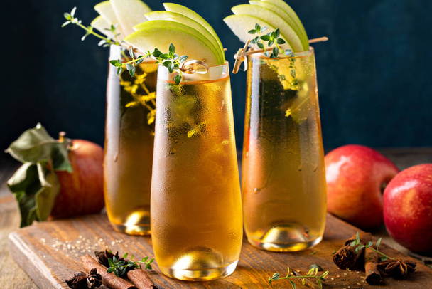 Apple cider mimosa for fall brunch, garnished with apple slices, autumn cocktail or mocktail idea - Photo, image