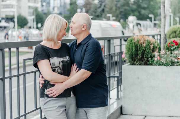 a man and his wife in black T-shirts are hugging in the city - Fotoğraf, Görsel