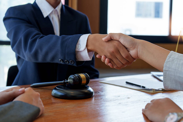Zakenman schudt handen om een deal te sluiten met zijn partner advocaten of advocaten bespreken van een contract overeenkomst - Foto, afbeelding